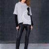 Model wearing black NAYA leatherette leggings paired with a grey abstract-print layered top, standing against a dark studio background.